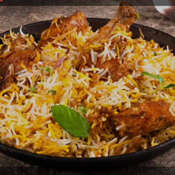 HotBits Indian Cuisine's chicken biryani, a flavorful rice dish with chicken pieces and a mint garnish.
